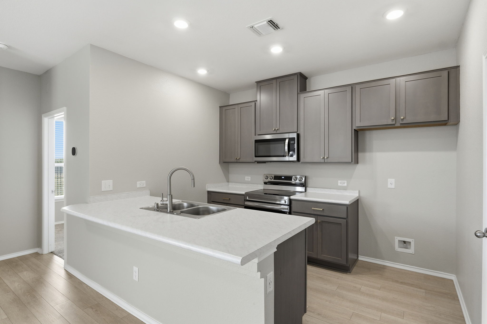 513 Thunder Valley Trail Georgetown, TX 78626 - Photo 5 of 15 Kitchen with a peninsula, stainless steel appliances, light countertops, recessed lighting, and light wood-type flooring