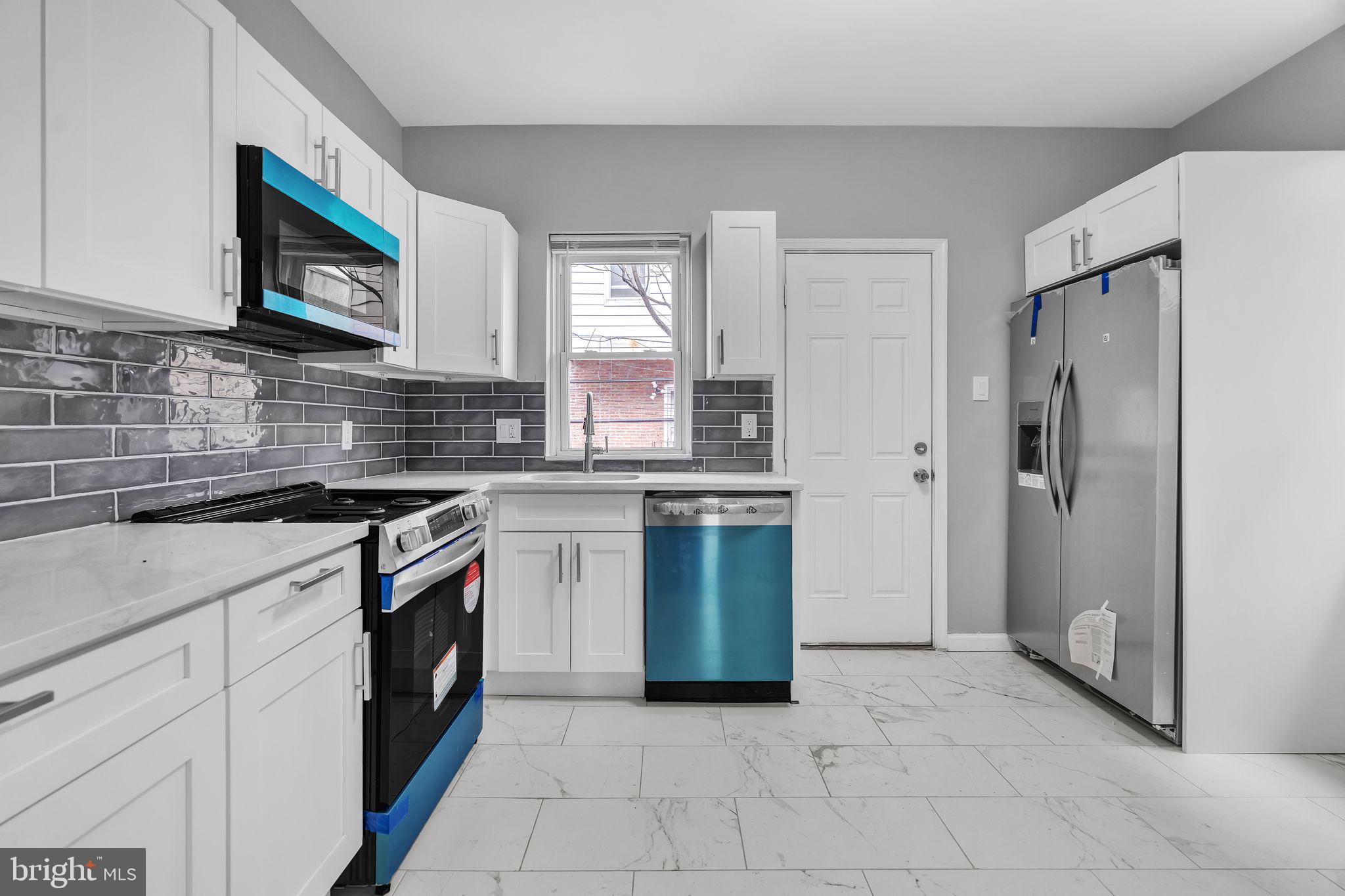 5745 Addison Street Philadelphia, PA 19143 - Photo 13 of 24 a kitchen with stainless steel appliances granite countertop a refrigerator sink and stove