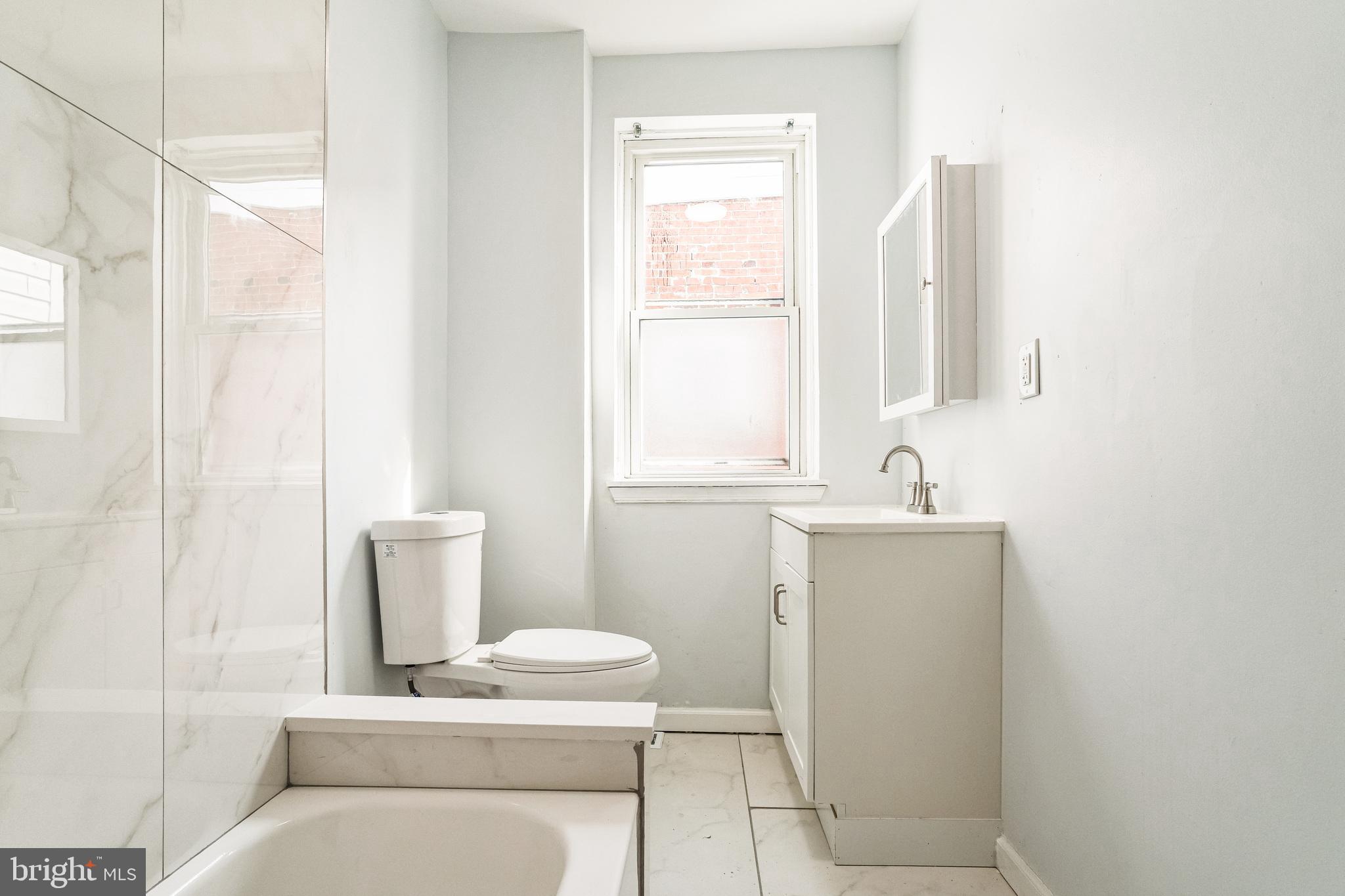5745 Addison Street Philadelphia, PA 19143 - Photo 20 of 24 a bathroom with a sink a toilet and a mirror