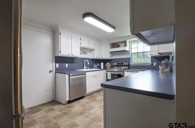 a kitchen with cabinets and window