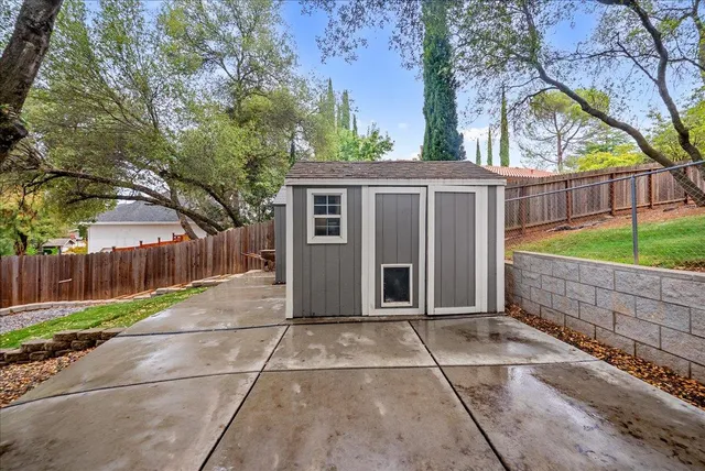 a view of backyard with green space and wooden fence
