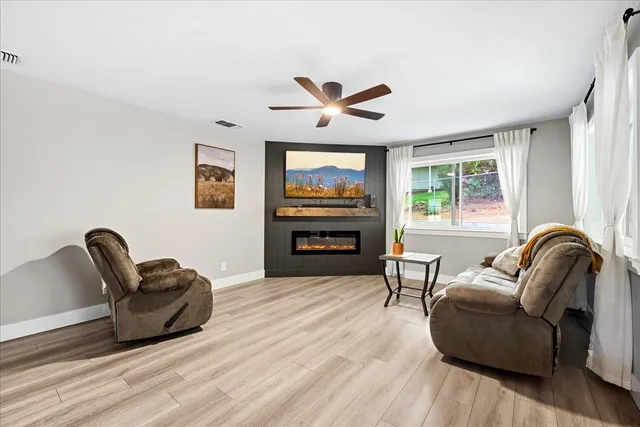 a living room with furniture a fireplace and a large window