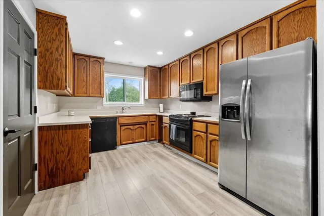 a kitchen with stainless steel appliances granite countertop a refrigerator sink and cabinets
