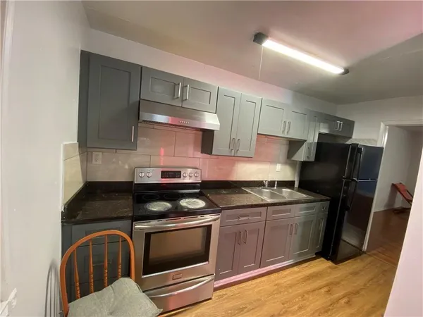 a kitchen with stainless steel appliances granite countertop a stove a sink and a refrigerator