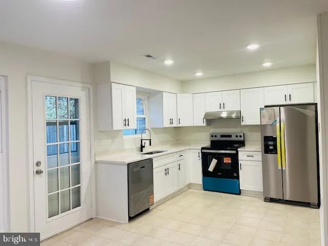 a kitchen with stainless steel appliances a refrigerator sink and stove