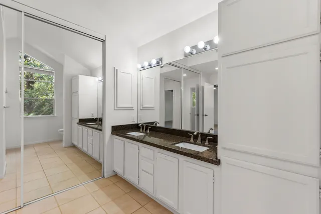 a bathroom with a granite countertop sink a mirror and a shower