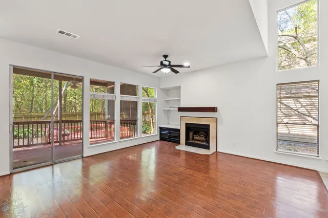 wooden floor fireplace and windows in an empty room