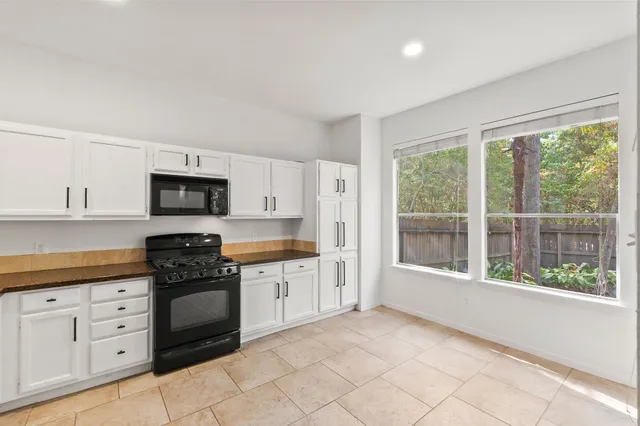 a kitchen with granite countertop a stove a sink and a refrigerator