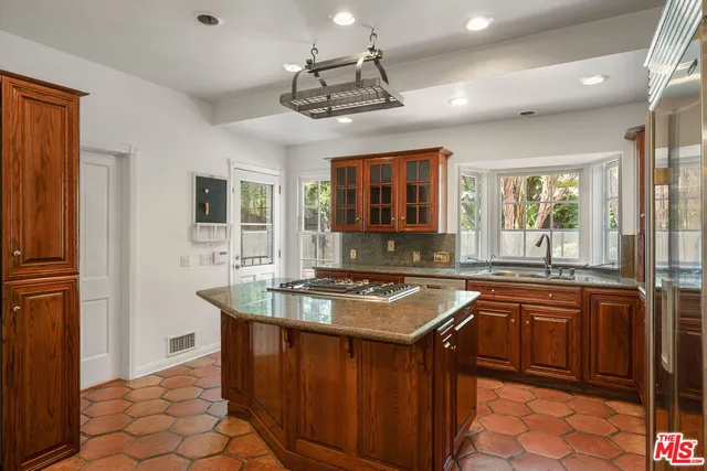a kitchen with stainless steel appliances granite countertop a sink a stove and a refrigerator
