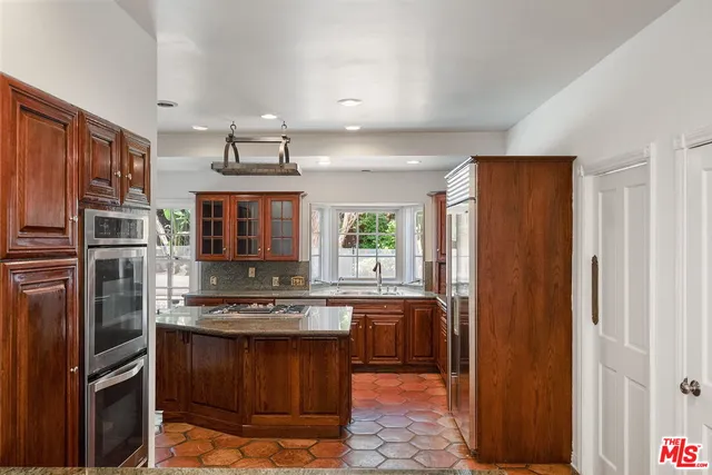 a kitchen with stainless steel appliances granite countertop a refrigerator stove and sink