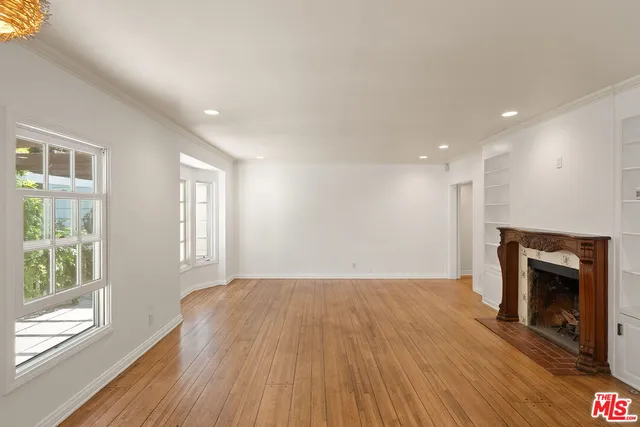 a view of an empty room with a fireplace and a window