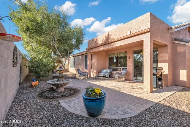 a view of a backyard with table and chairs and a barbeque