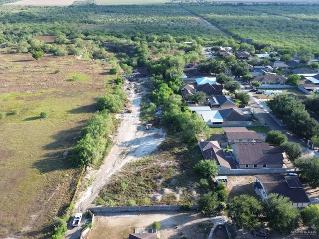 an aerial view of residential houses with outdoor space and trees