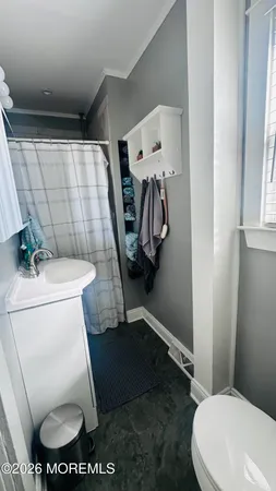a white toilet sitting next to a bathroom sink and a mirror
