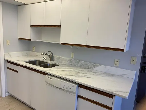 a kitchen with a sink cabinets and a wooden floor