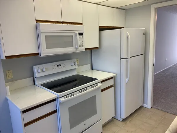 a kitchen with a stove refrigerator and microwave