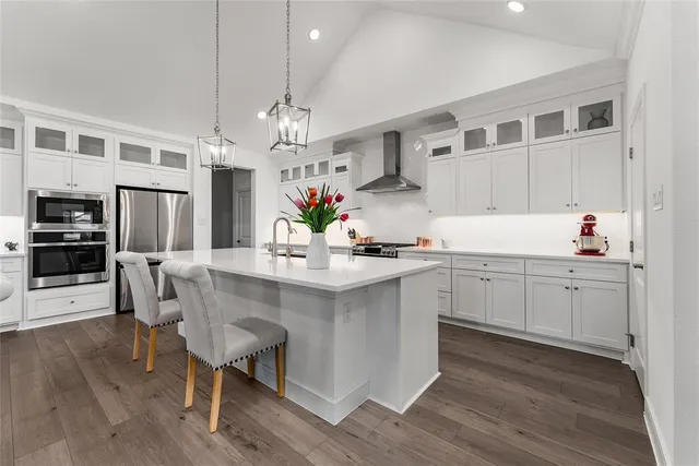 a kitchen with kitchen island granite countertop a sink cabinets and wooden floor