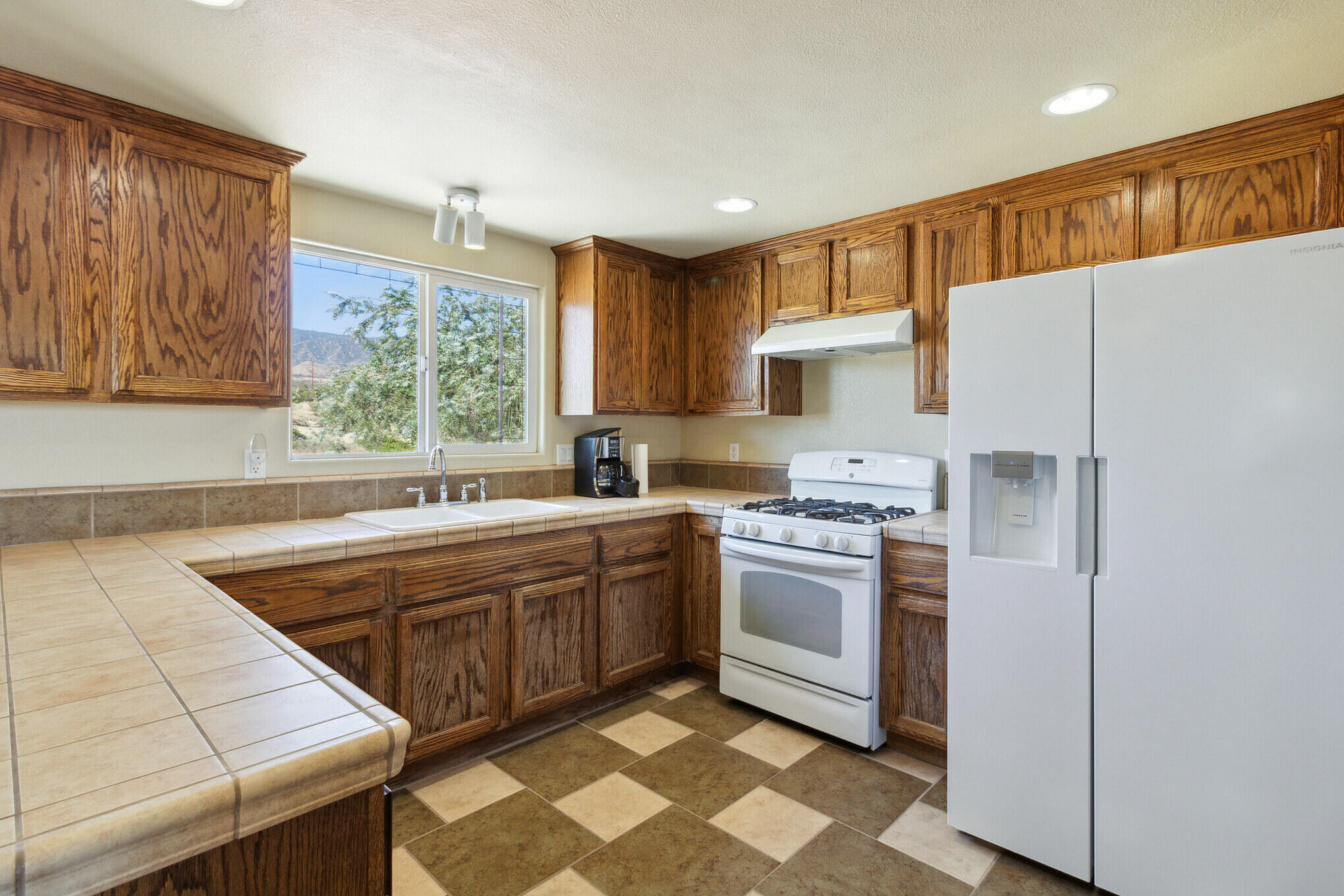 381 Calaveras Road Pinon Hills, CA 92372 - Photo 6 of 27 a kitchen with stainless steel appliances granite countertop a sink a stove a refrigerator and island with wooden cabinets