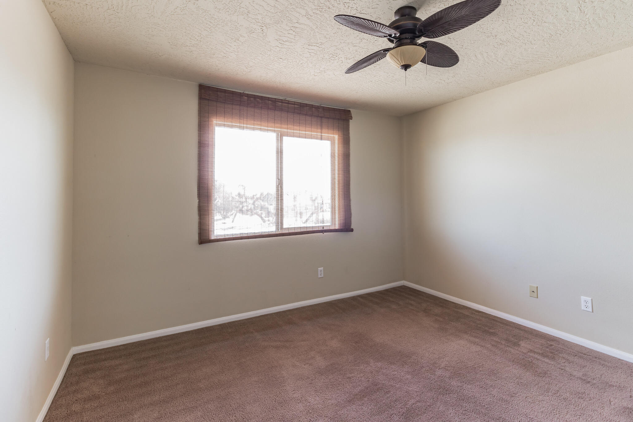 381 Calaveras Road Pinon Hills, CA 92372 - Photo 10 of 27 an empty room with a window and a fan
