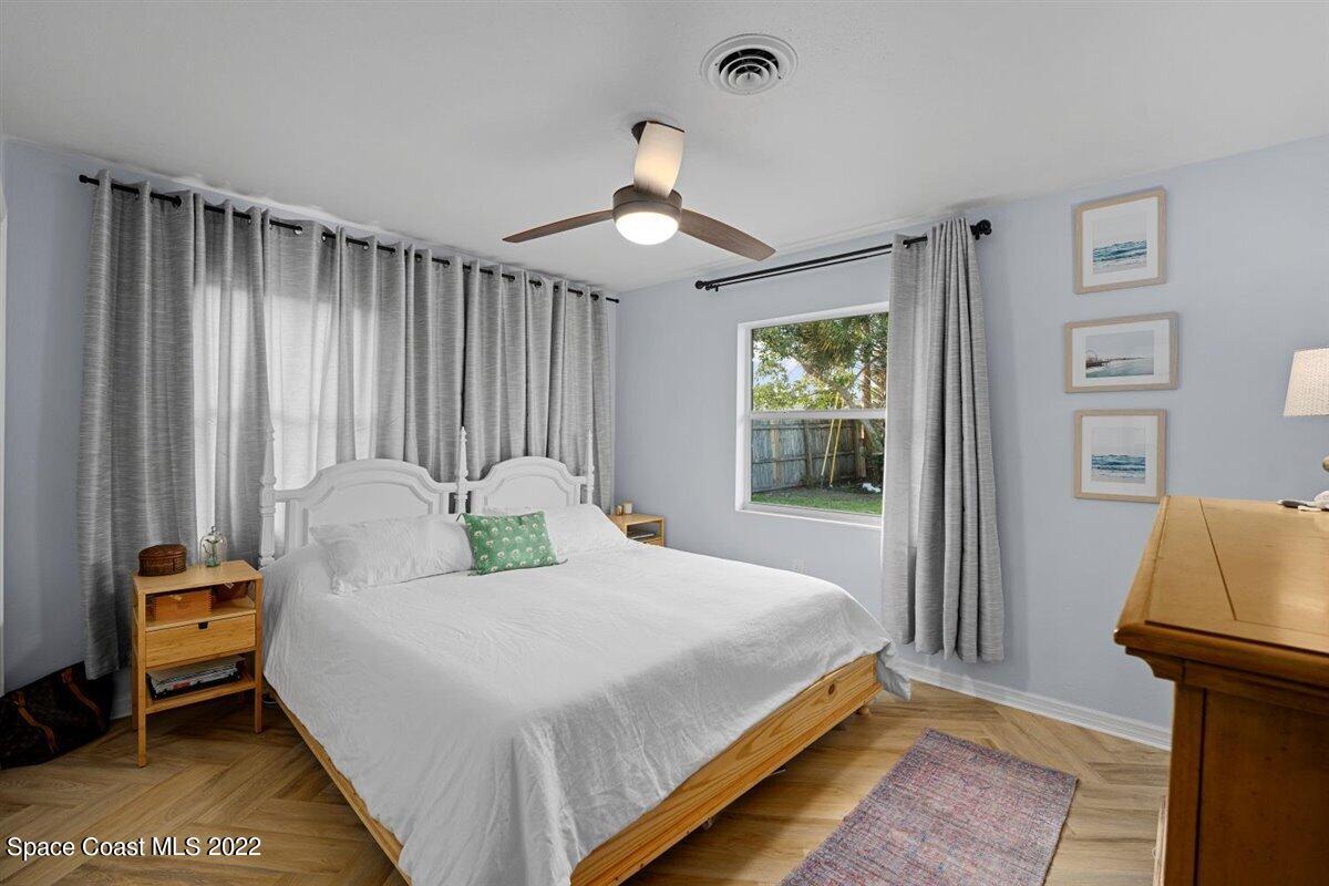 623 Bermuda Road Cocoa Beach, FL 32931 - Photo 18 of 29 a bedroom with a bed and a chandelier