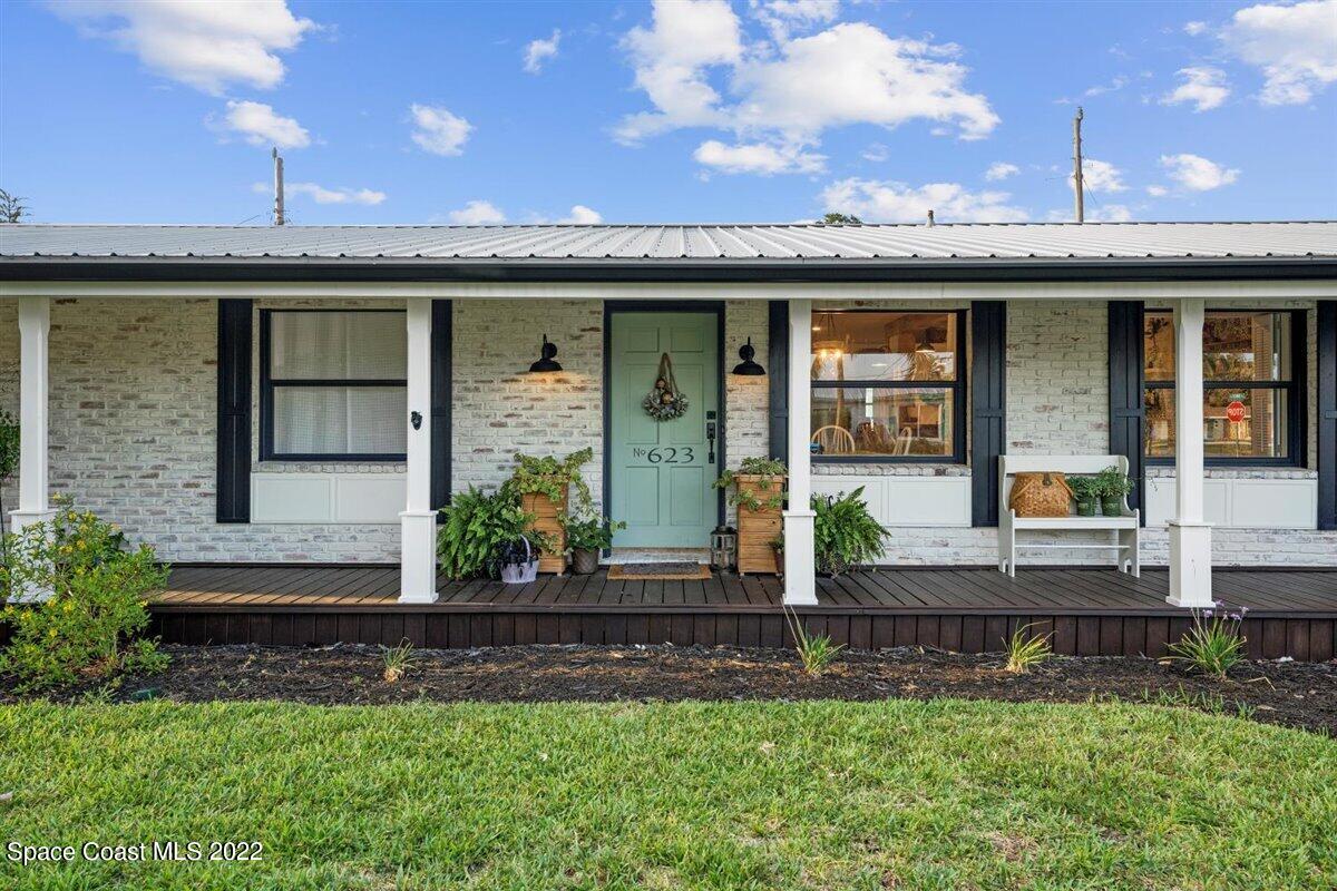623 Bermuda Road Cocoa Beach, FL 32931 - Photo 5 of 29 a front view of a house with a garden