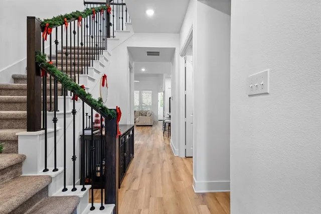 a view of a hallway with wooden floor and entryway