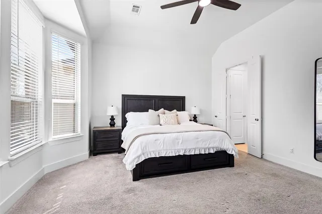 a spacious bedroom with a bed and large window