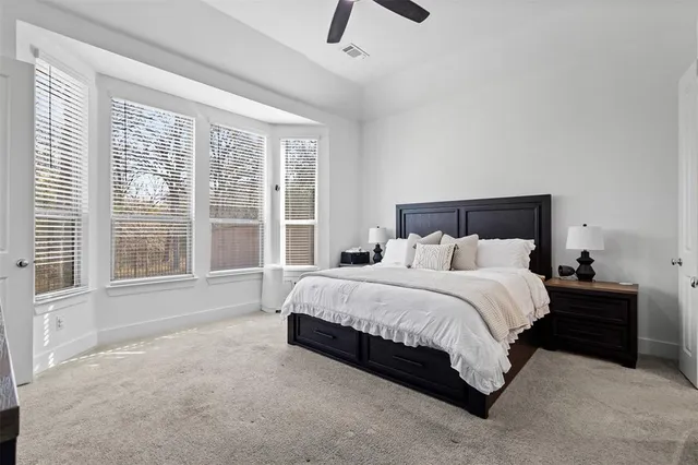 a large bed sitting in a bedroom next to a large window