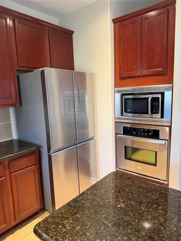 a kitchen with a refrigerator and a stove top oven