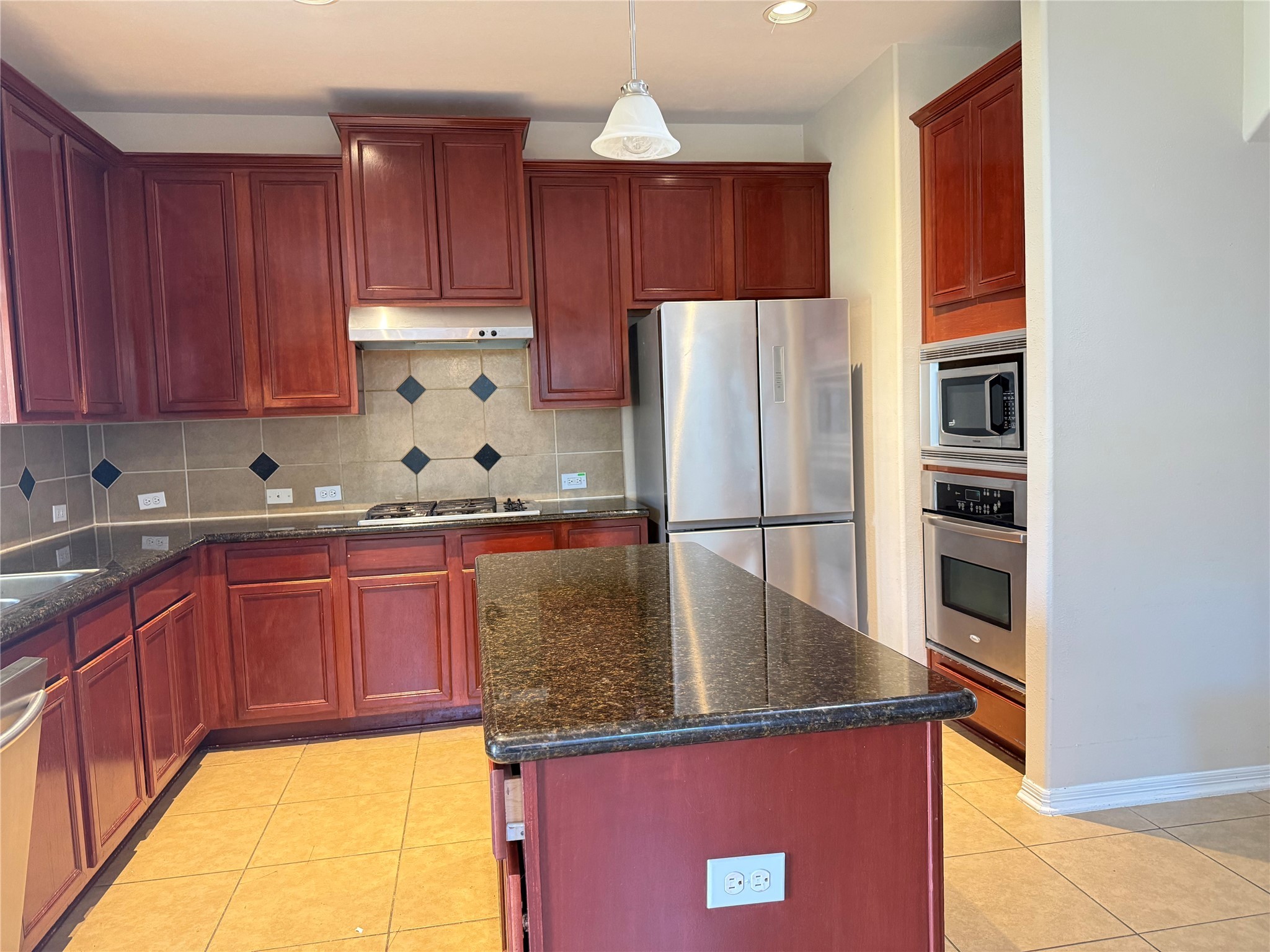10930 Reston Point Drive Richmond, TX 77406 - Photo 7 of 26 a kitchen with stainless steel appliances granite countertop a refrigerator a stove and a sink with wooden cabinets