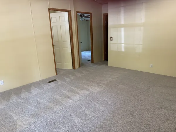 an empty room with closet and wooden door