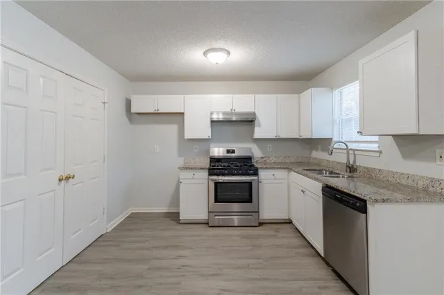 a kitchen with granite countertop a stove and a sink