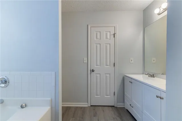 a spacious bathroom with a bathtub sink and mirror