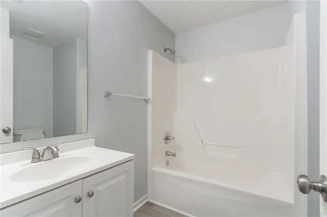 a bathroom with a bathtub sink vanity and a mirror