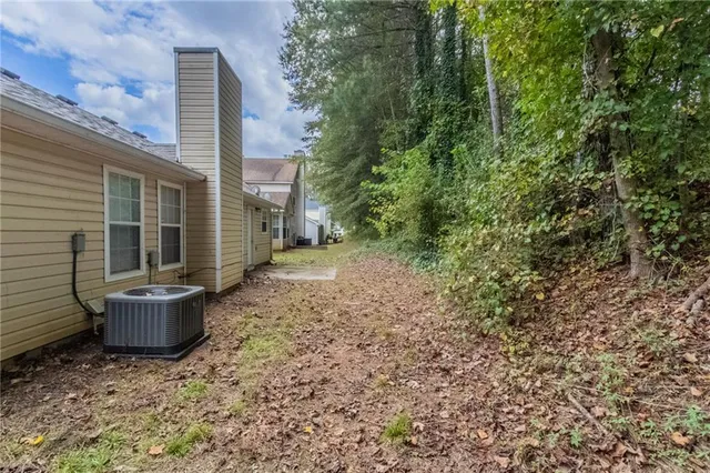 a view of a backyard with plants and large tree