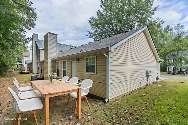 a view of a house with backyard and sitting area