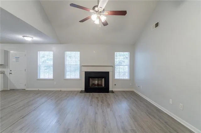 a view of an empty room with a fireplace and a window