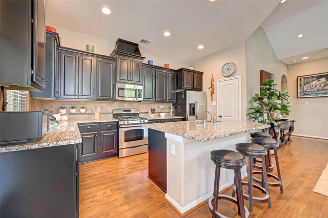 a kitchen with a sink stove top oven and refrigerator