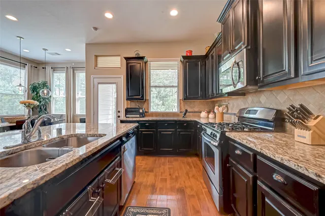 a kitchen with a sink stove top oven and microwave