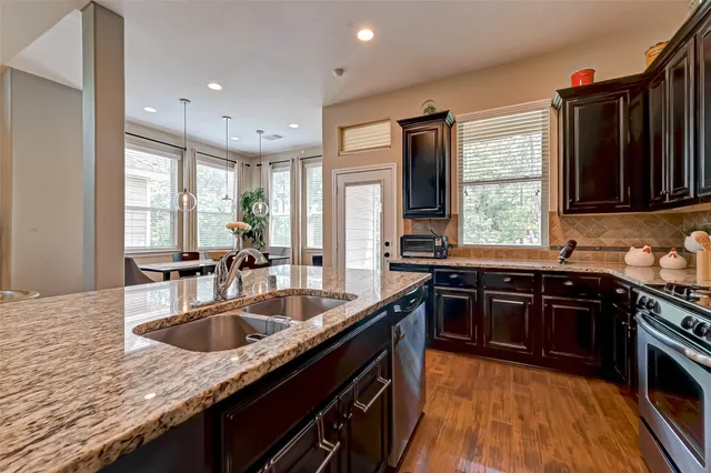 a kitchen with stainless steel appliances granite countertop a sink stove and cabinets
