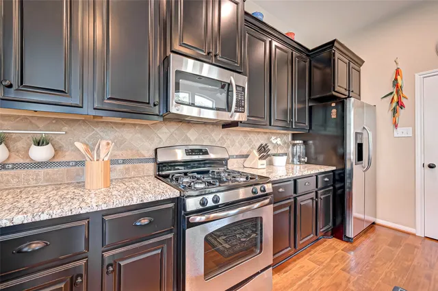a kitchen with granite countertop cabinets stainless steel appliances and a sink