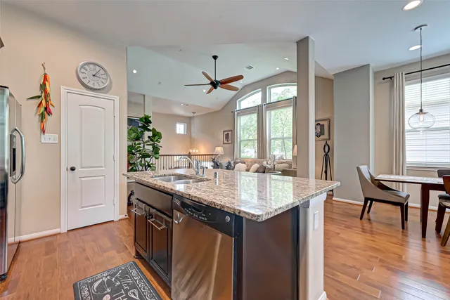 a kitchen with granite countertop a sink a counter top space and living room view