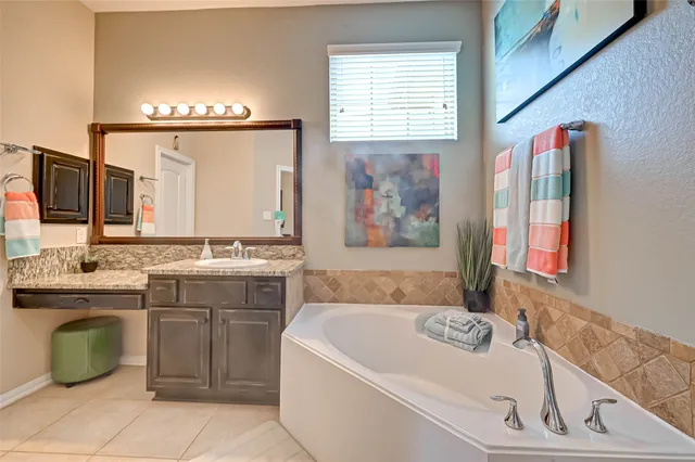 a spacious bathroom with a granite countertop sink and a mirror