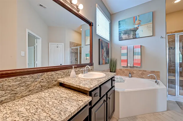 a bathroom with a tub sink and mirror