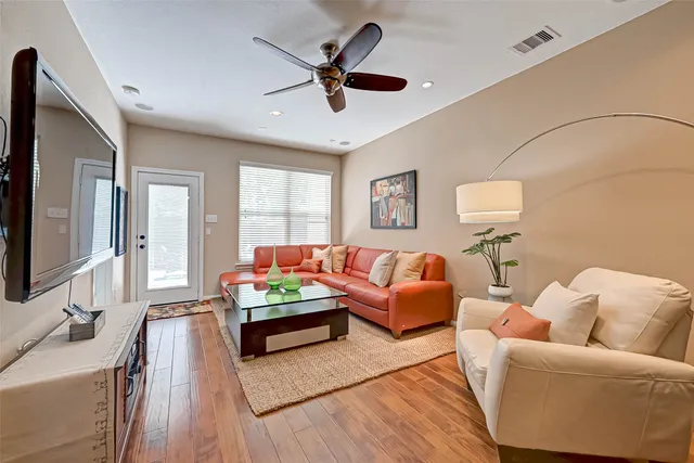 a living room with furniture and a wooden floor