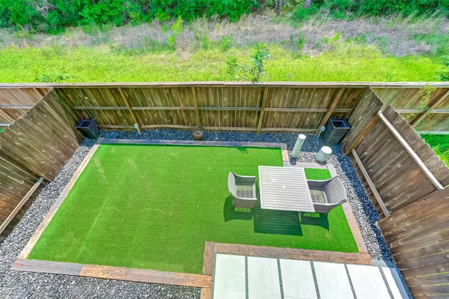 a view of a chair and table in the back yard of the house
