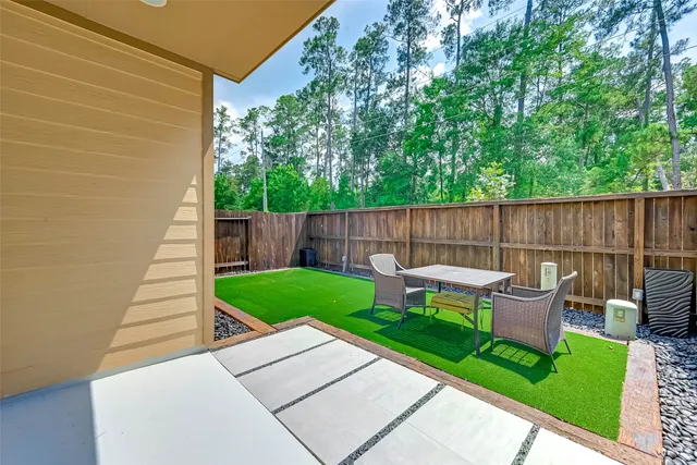 a view of a backyard with wooden fence and a bench