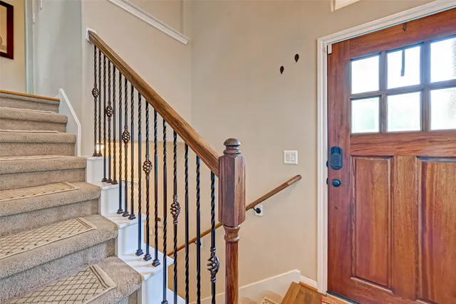 a view of staircase with railing and a window