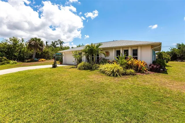 a view of a house with a yard and potted plants