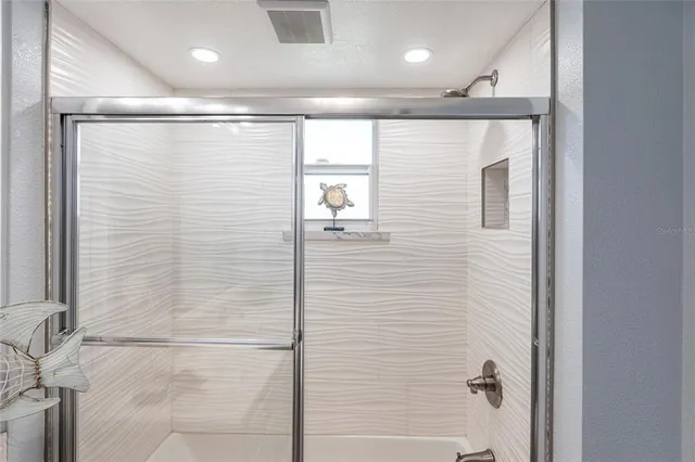a bathroom with a shower and a glass door